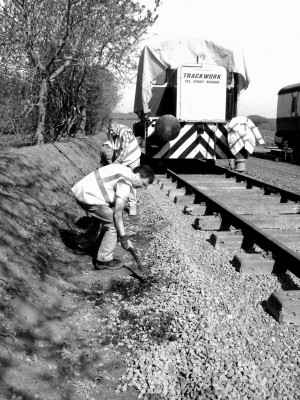 Ian C and Jack tidy up ballast at the edge of the running line.