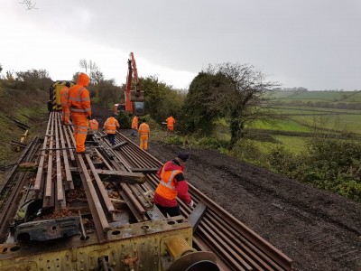Rails being offloaded from the flat wagon in preparation for laying to form the extended running line.
